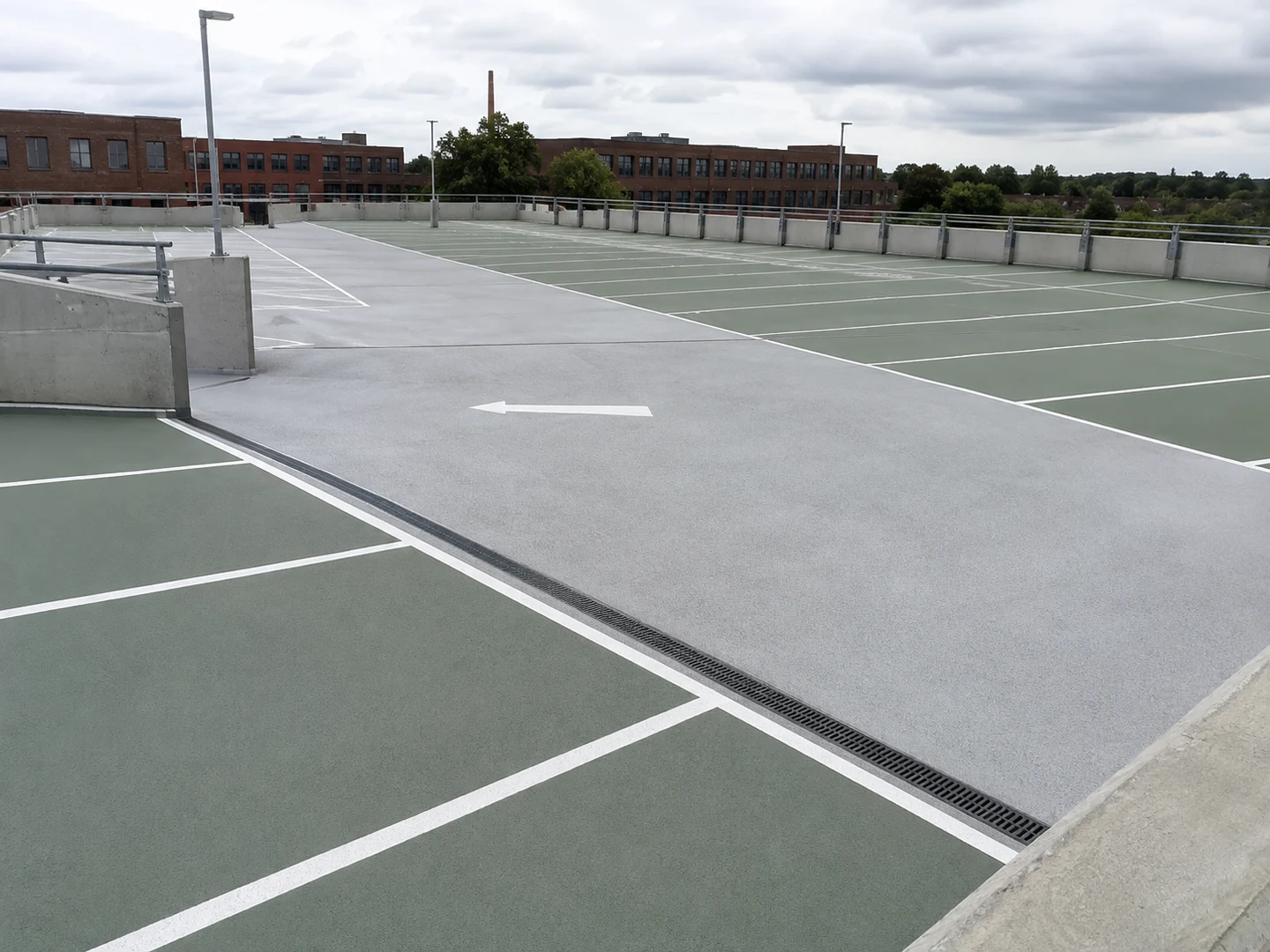 Udført parkeringsdæk med grå kørespor, grønne parkeringsfelter og hvide markeringer.