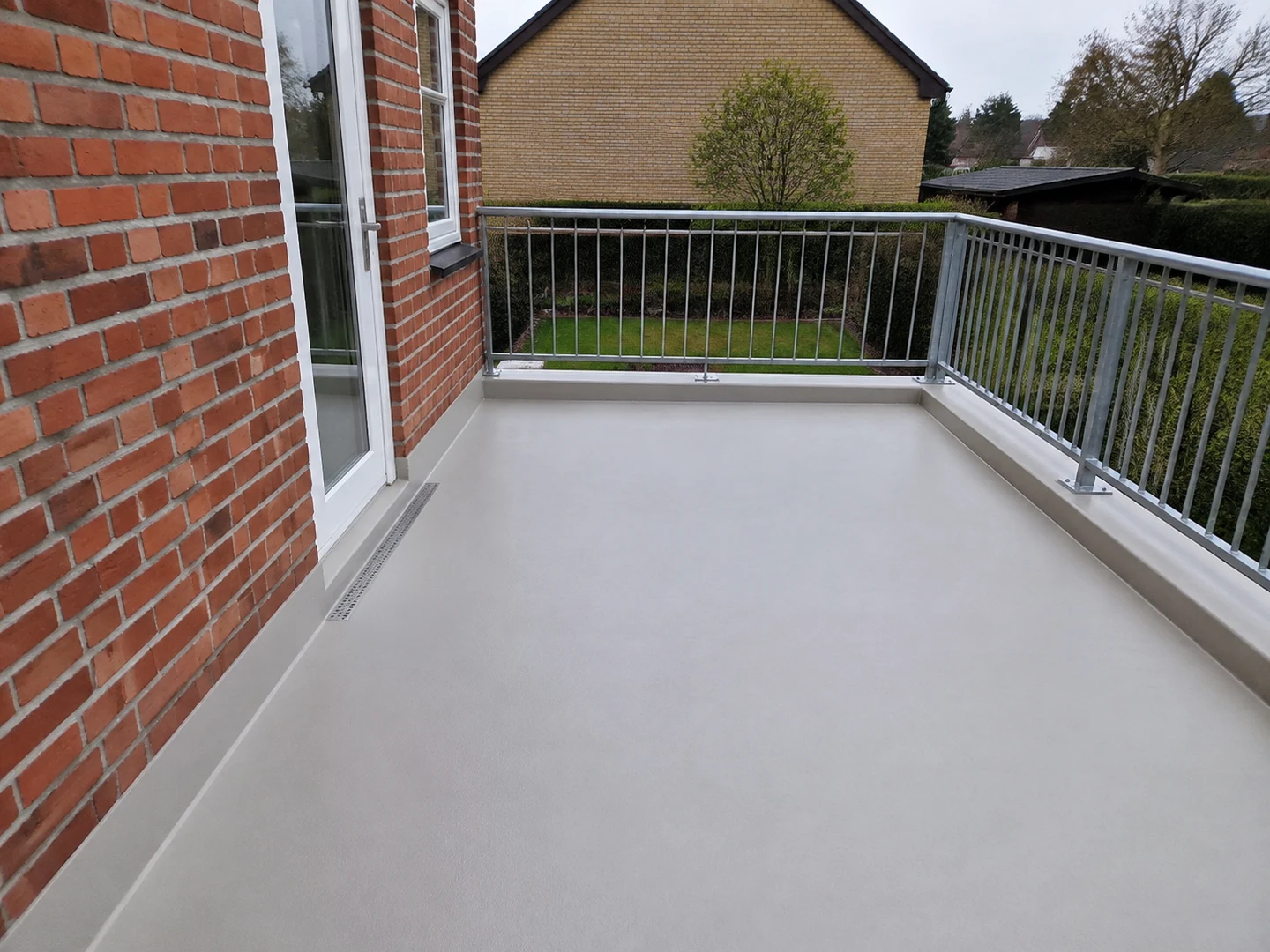 Udført tagterrasse med grå membranoverflade, murstensfacade og galvaniseret værn.